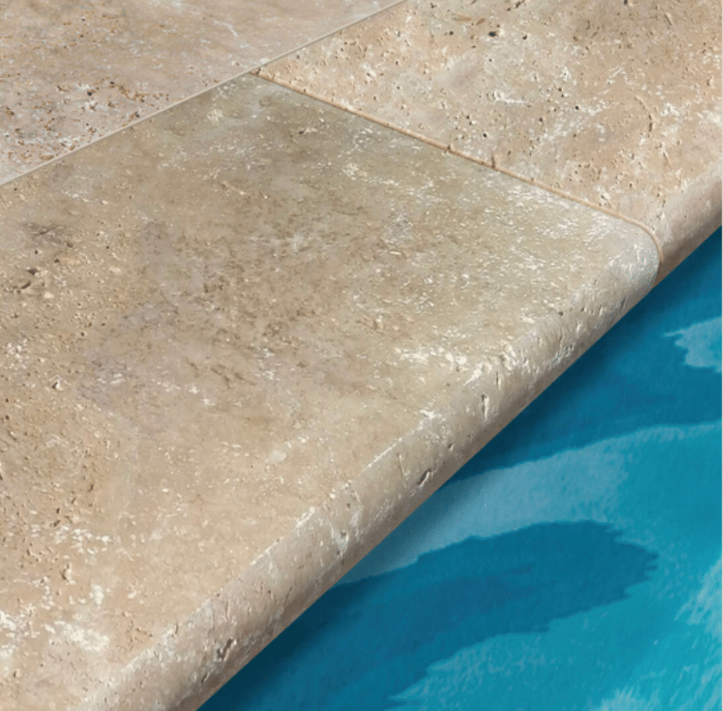 margelle en travertin avec bord demi rond autour d'une piscine